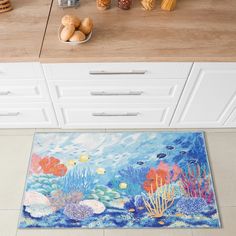 a kitchen area rug with fish and corals on the floor next to a counter