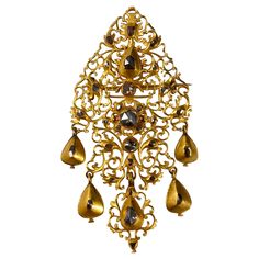 Antique diamond sequile pendant/brooch in 19.2kt yellow gold, Portugal, early 18th century. This Portuguese jewel from the Georgian period of an intricately pierced openwork "sequilé” design is richly accented throughout with 31 rose-cut and table-cut diamonds, the yellow gold embellished with profuse chiseled and scalloped decoration with volutes and foliate decoration, suspending five pear-shaped diamond-set articulated pendants. In line with other artefacts from this Rococo period, the back o Victorian Gold Brooches With Jewels, Victorian Gold Pendant Brooches, Traditional Yellow Gold Pendant Brooches, Antique Gold Brooches With Jewels, Ornate Yellow Gold Brooch For Ceremonial Use, Ornate Yellow Gold Brooches For Ceremonial Use, Ornate Yellow Gold Brooches For Ceremonial Occasions, Ornate Gold Brooches With Jewels, Ceremonial Gold Brooches With 17 Jewels