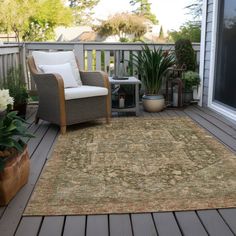 an outdoor area rug on a deck with chairs and potted plants