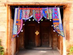 the entrance to an old building decorated with colorful cloths