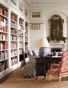 a living room filled with furniture and bookshelves covered in lots of bookcases