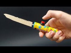 a hand holding a yellow and red toy knife