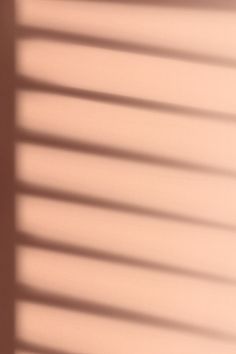 the shadow of a window with blinds on it