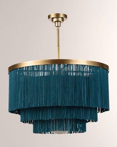 a blue chandelier hanging from a ceiling fixture with fringes on the bottom