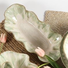 some flowers are sitting in front of two dishes