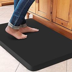 a person stepping on a black mat in the kitchen