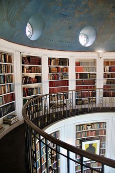 a spiral staircase in a library filled with books