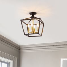 a light fixture hanging from the ceiling in a room with white walls and trimmings