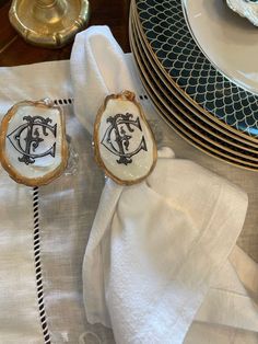 two pieces of glass sitting on top of a white table cloth next to plates and silverware