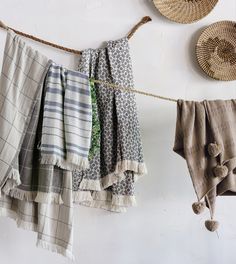 several towels hanging on a clothes line next to baskets and wall hooks with pom - poms