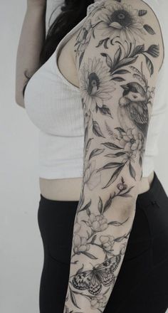 a woman's arm with flowers and birds tattooed on the back of her arm