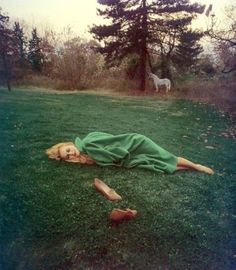 a woman laying on the grass with her head down