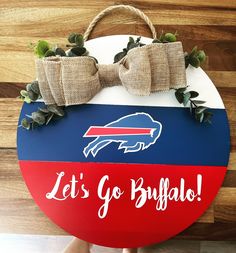 a wooden sign that says, let's go buffalo on it with a bow