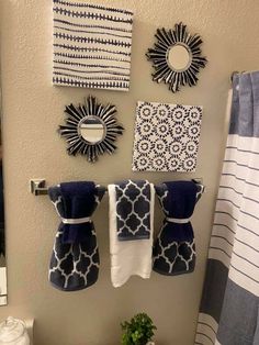 towels are hanging on the wall next to a toilet in a bathroom with blue and white decor