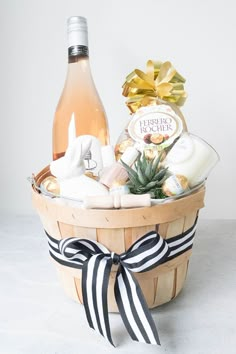 a wine bottle in a wooden basket filled with bath and body care items next to a white wall