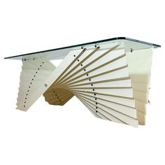 a glass and metal coffee table with multiple sections on each side, in the shape of a fan