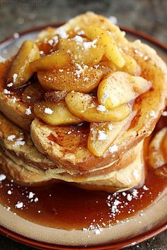 a stack of pancakes topped with bananas and powdered sugar