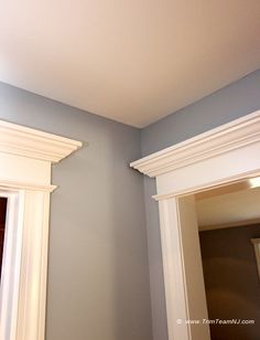 a bathroom with blue walls and white trim on the wall, along with two mirrors