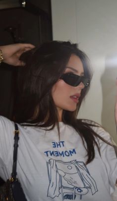 a woman with sunglasses on taking a selfie in front of a mirror while wearing a t - shirt that says the moment