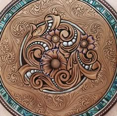 an intricately designed wooden plate with flowers on it