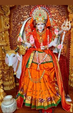 a statue of the hindu god sitting in front of a cow