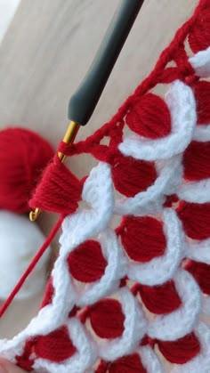 the crochet pattern is being worked on by someone using a knitting needle and yarn