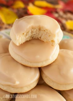 a pile of iced donuts sitting on top of each other in front of a plate