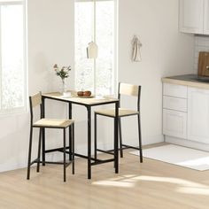 a kitchen table with two stools next to it on top of a hard wood floor