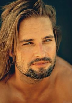 a shirtless man with long hair and beard