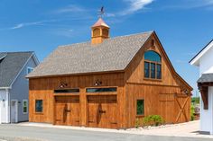 a large wooden building with two garages and a steeple