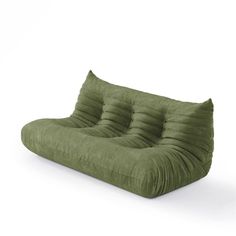 a green couch that is sitting on top of a white floor and it's made out of fabric