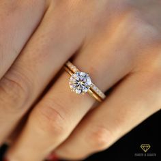 a woman's hand with two gold rings and a diamond ring on her finger