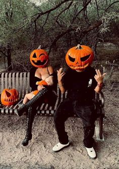 two people sitting on a bench with pumpkin heads