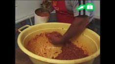 a person is mixing food in a yellow bucket