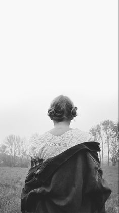 black and white photograph of a woman in a field with her back to the camera