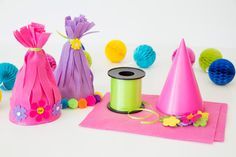 colorful party hats and decorations on a white surface