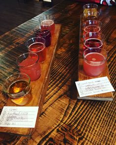 there are many glasses on the table with different drinks in them, and one is empty