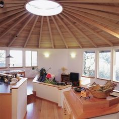 a living room filled with furniture and lots of windows next to a wooden floored ceiling