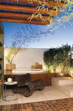 an outdoor jacuzzi tub in the middle of a patio with steps leading up to it