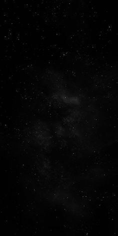 black and white photograph of the night sky with stars in the dark, overcast skies