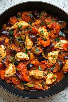 a skillet filled with eggplant, carrots and other vegetables