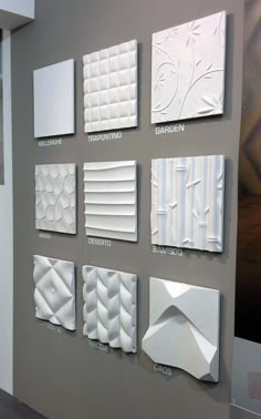 a wall with many different types of decorative tiles on it's sides, all in white and grey