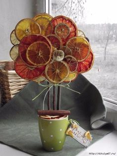 a vase filled with oranges sitting on top of a window sill