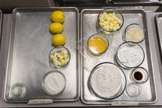 two trays filled with different types of food on top of a counter next to each other