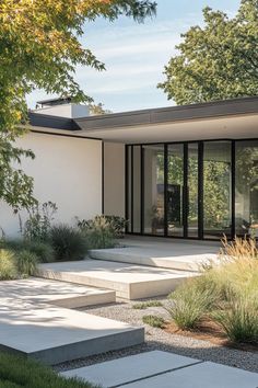 a modern house with large windows and steps leading up to the front door