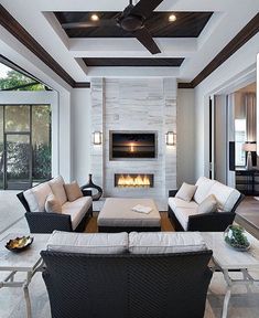 a living room filled with furniture and a fire place in the middle of it's wall