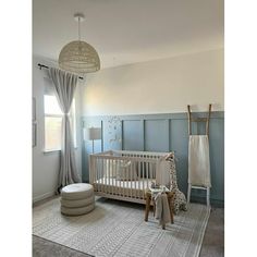 a baby's room with a crib, rocking chair and rugs on the floor