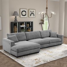 a large gray couch sitting on top of a wooden floor next to a white rug