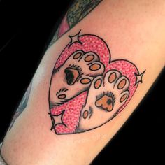 a heart shaped tattoo with paw prints on it