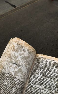 an open book sitting on top of a sidewalk